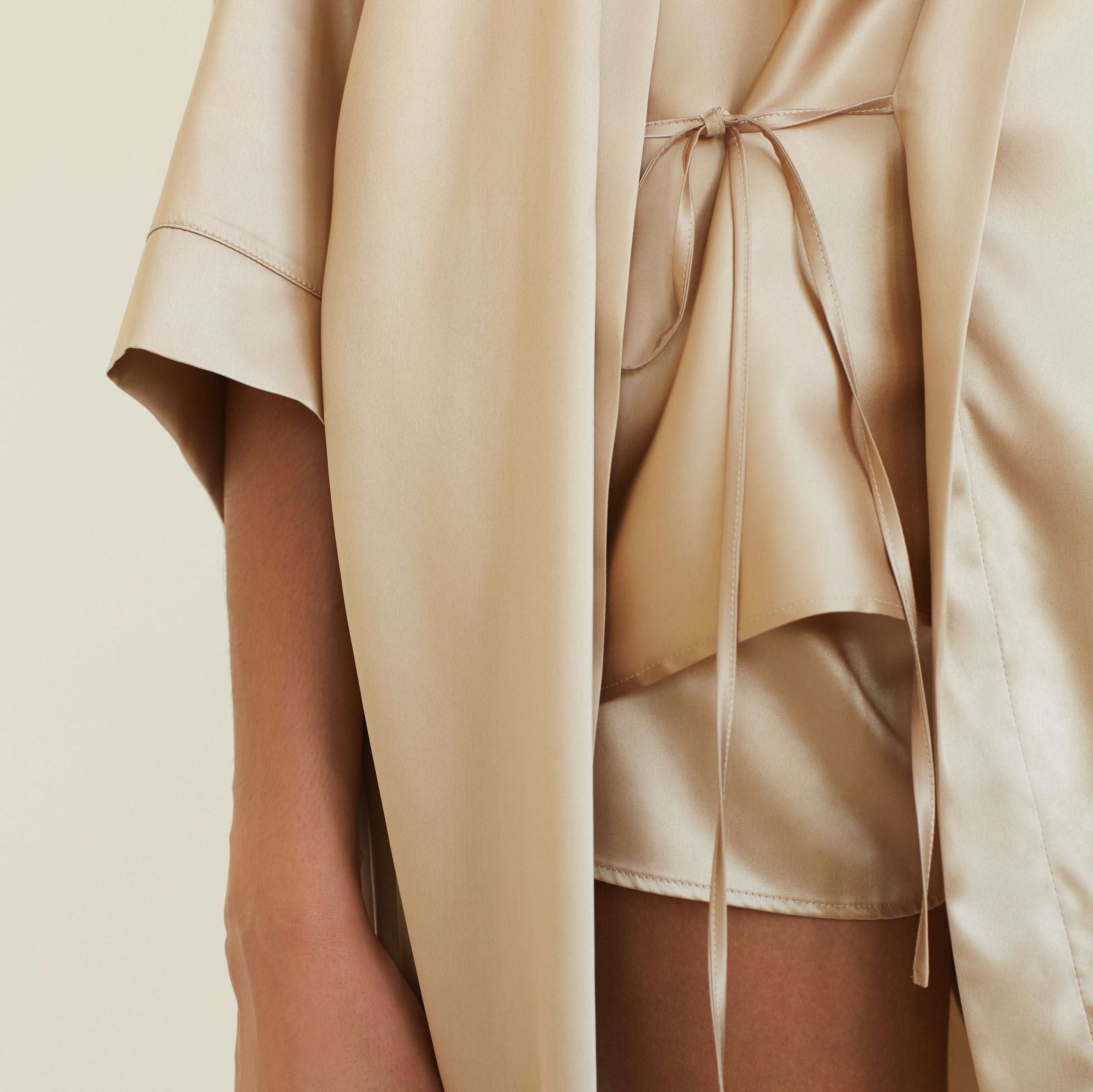 Beige Close-up of the tie detail on the beige silk robe, showing the luxurious and soft fabric texture.