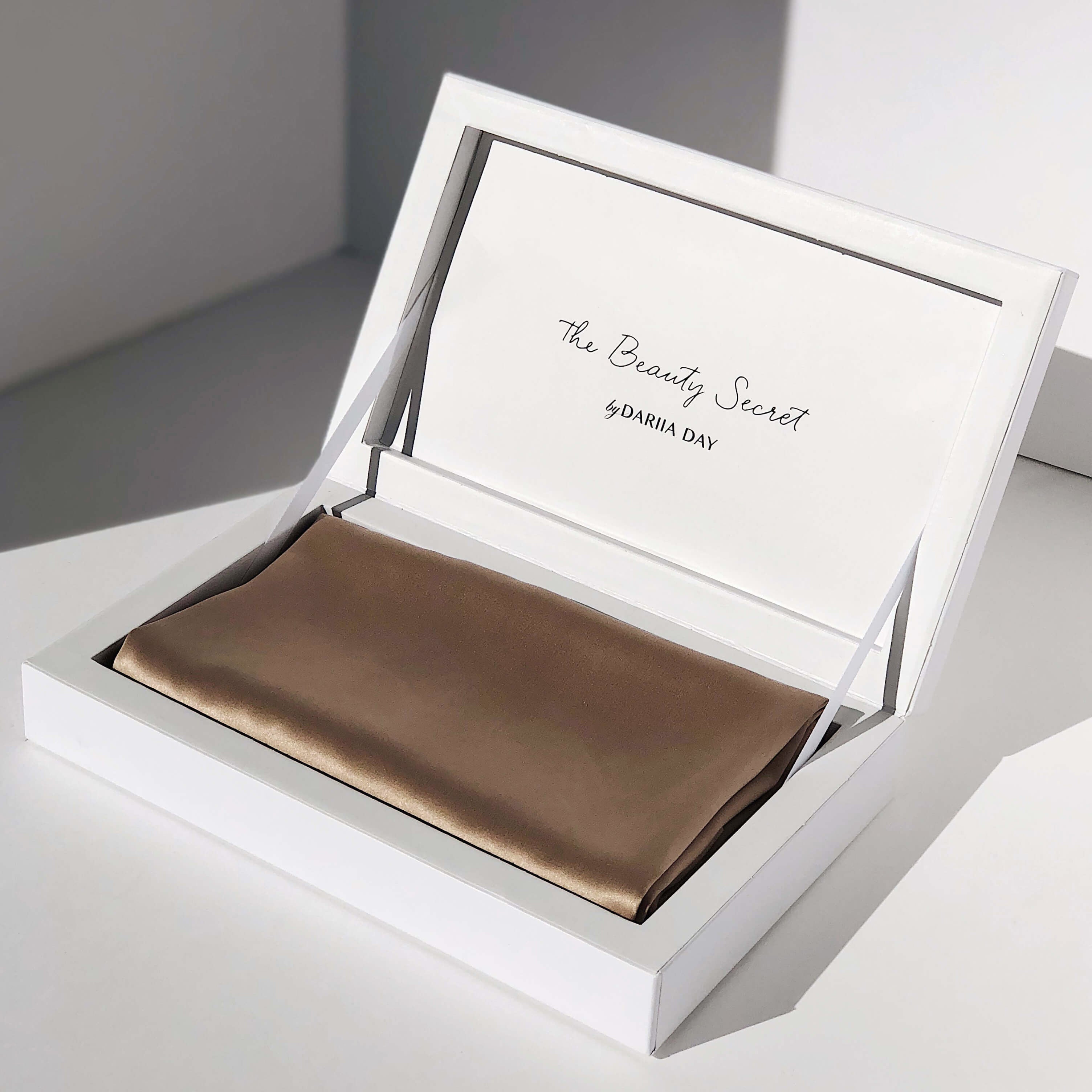 Beige silk pillowcase by Dariia Day displayed in an elegant white presentation box.
