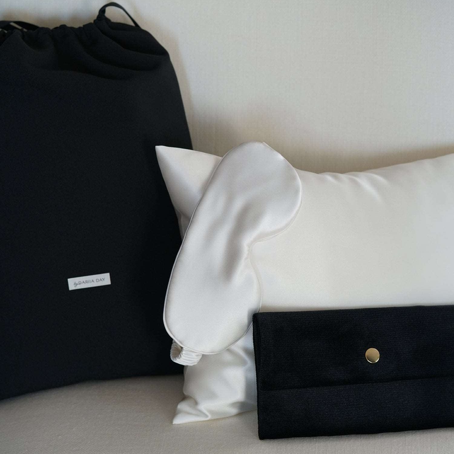 White Eye mask in powder white with a velvet puch and a bag.