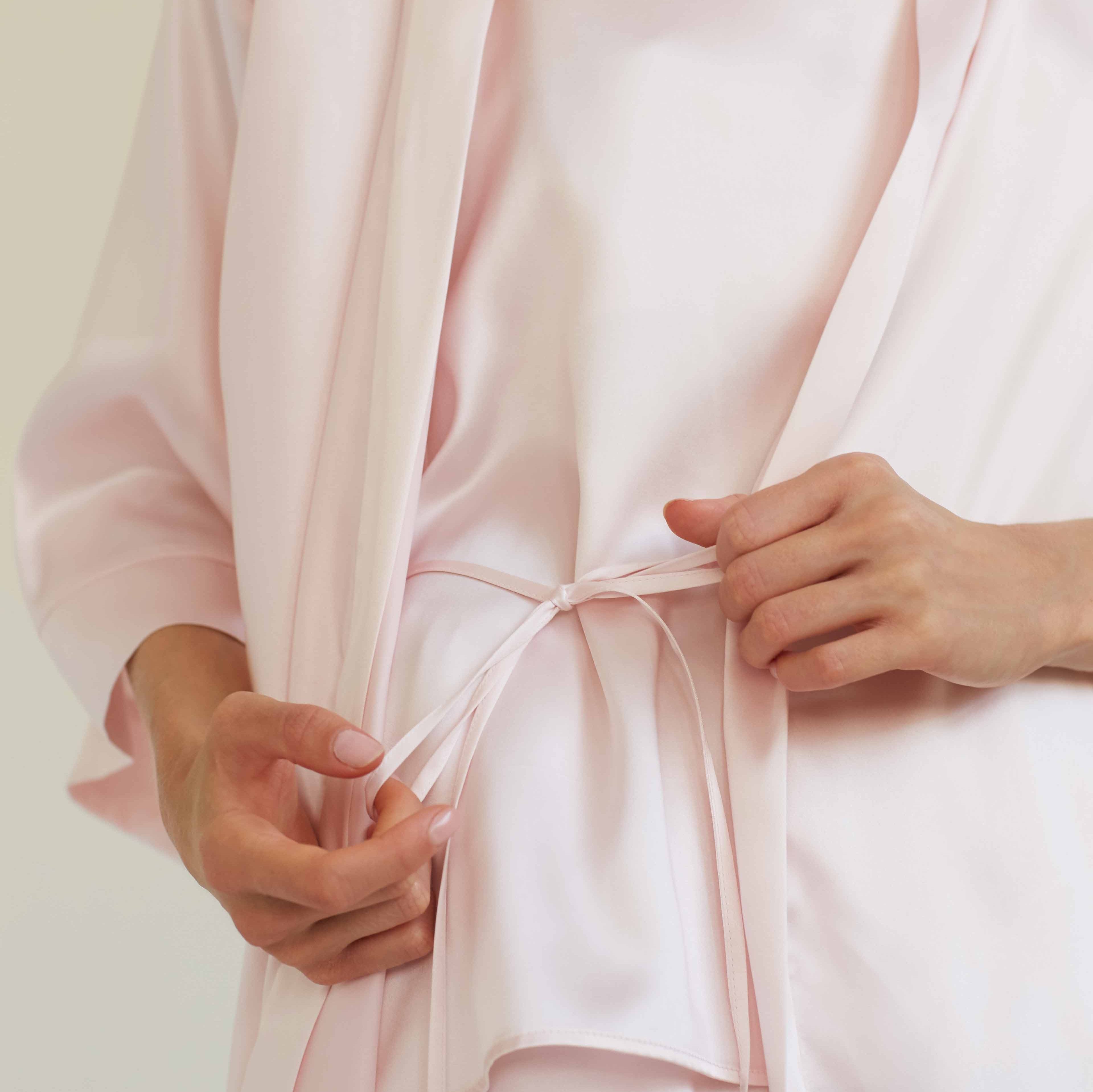 Pink Close-up of the blush pink silk robe belt detail by Dariia Day, showcasing the smooth and elegant fabric with a delicate tie waist for a perfect fit.