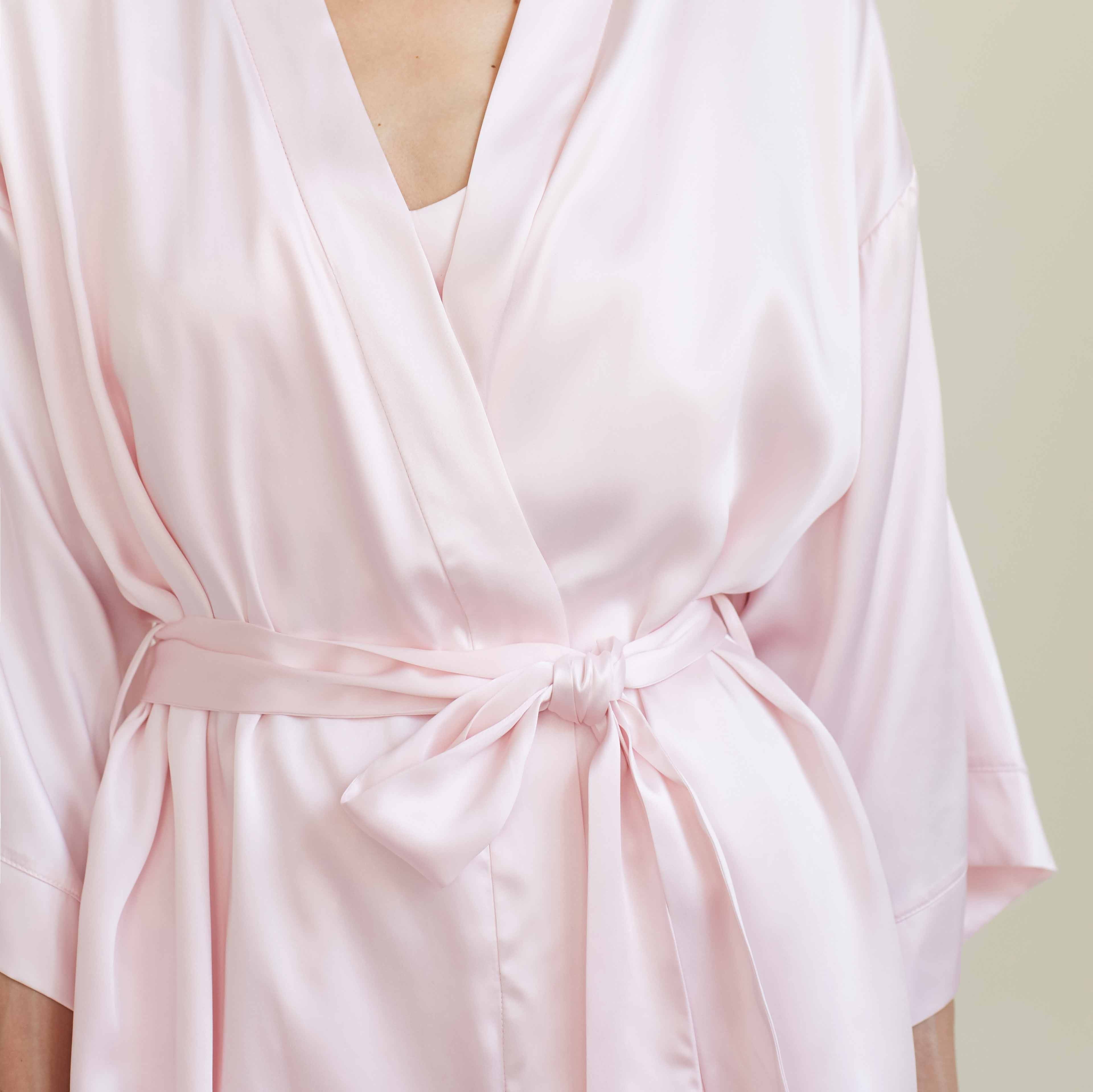 Pink A close-up view of the blush pink silk robe by Dariia Day, focusing on the tie front detail that adds elegance and sophistication to the luxurious robe.