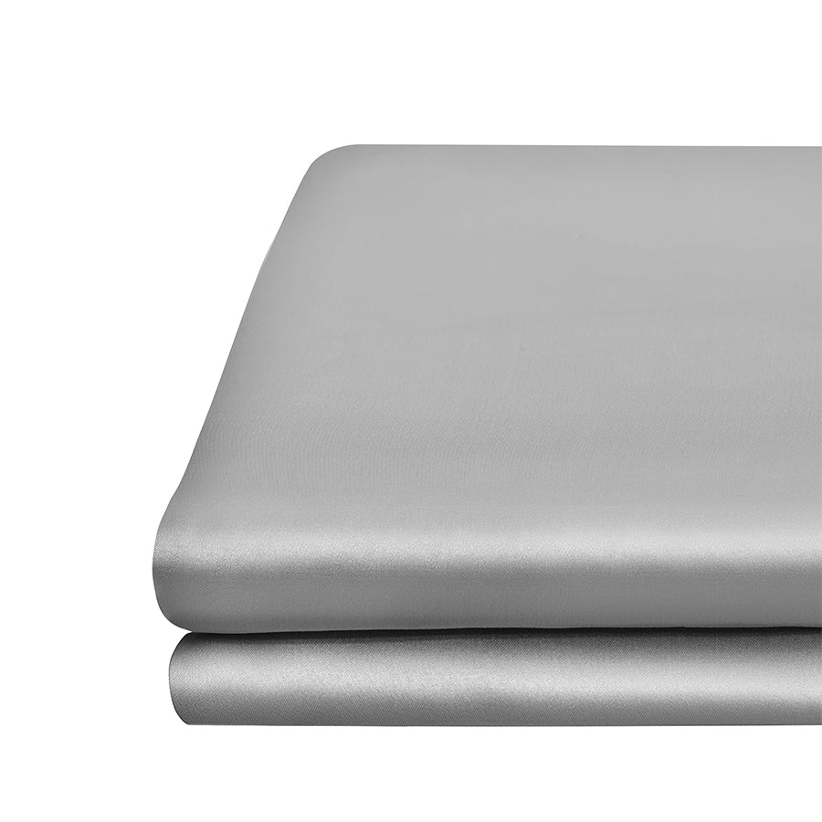 Grey Close-up of silver grey silk flat sheet neatly folded, highlighting its sleek and lustrous fabric from by Dariia Day.
