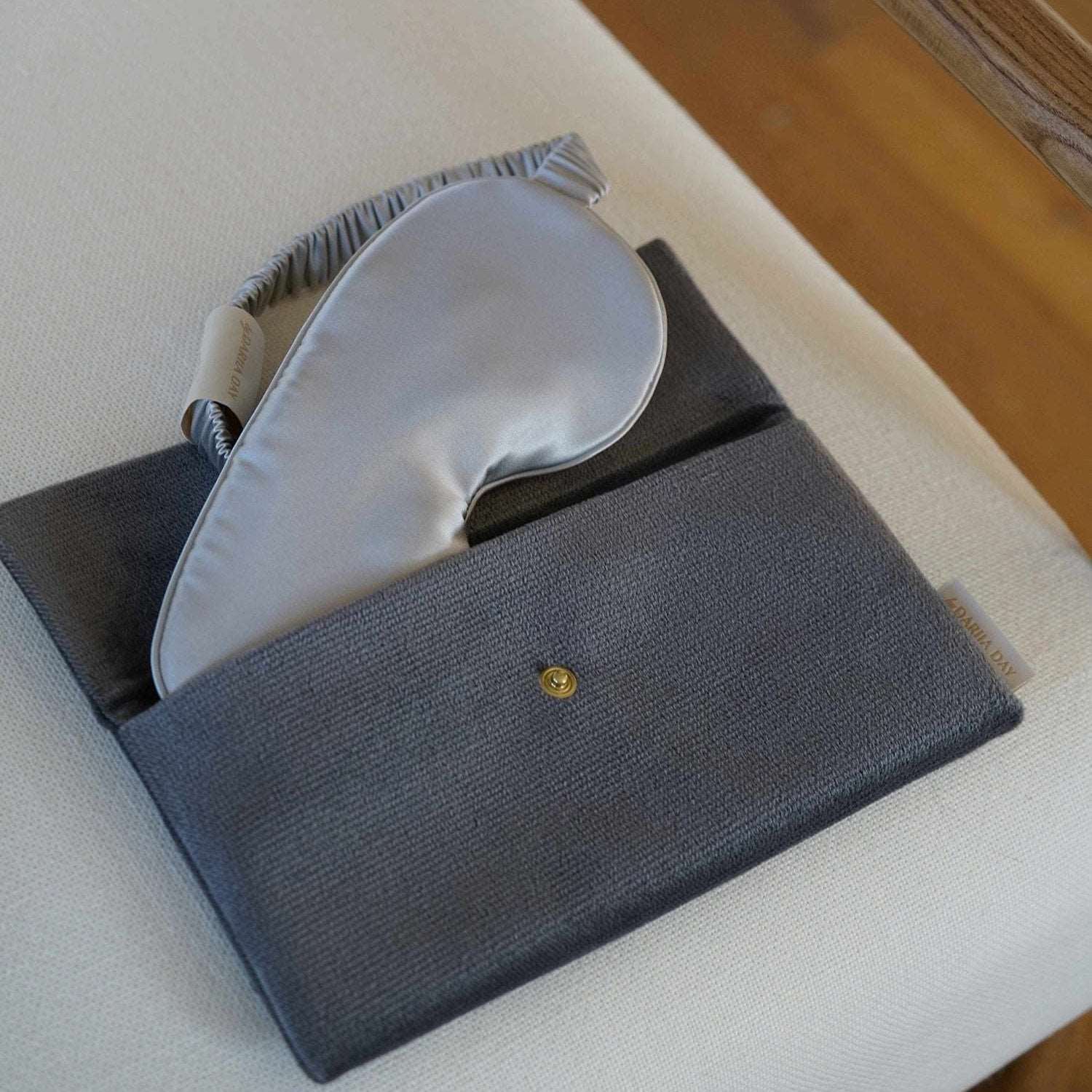 Moonstone Dariia Day Moonstone Velvet Pouch with a matching silk eye mask on a beige chair.
