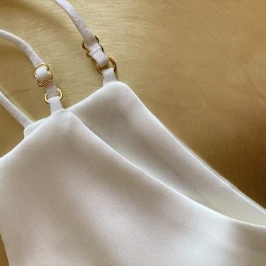 White Close-up of Dariia Day's powder white silk face mask, highlighting the adjustable ear loops and fine stitching.