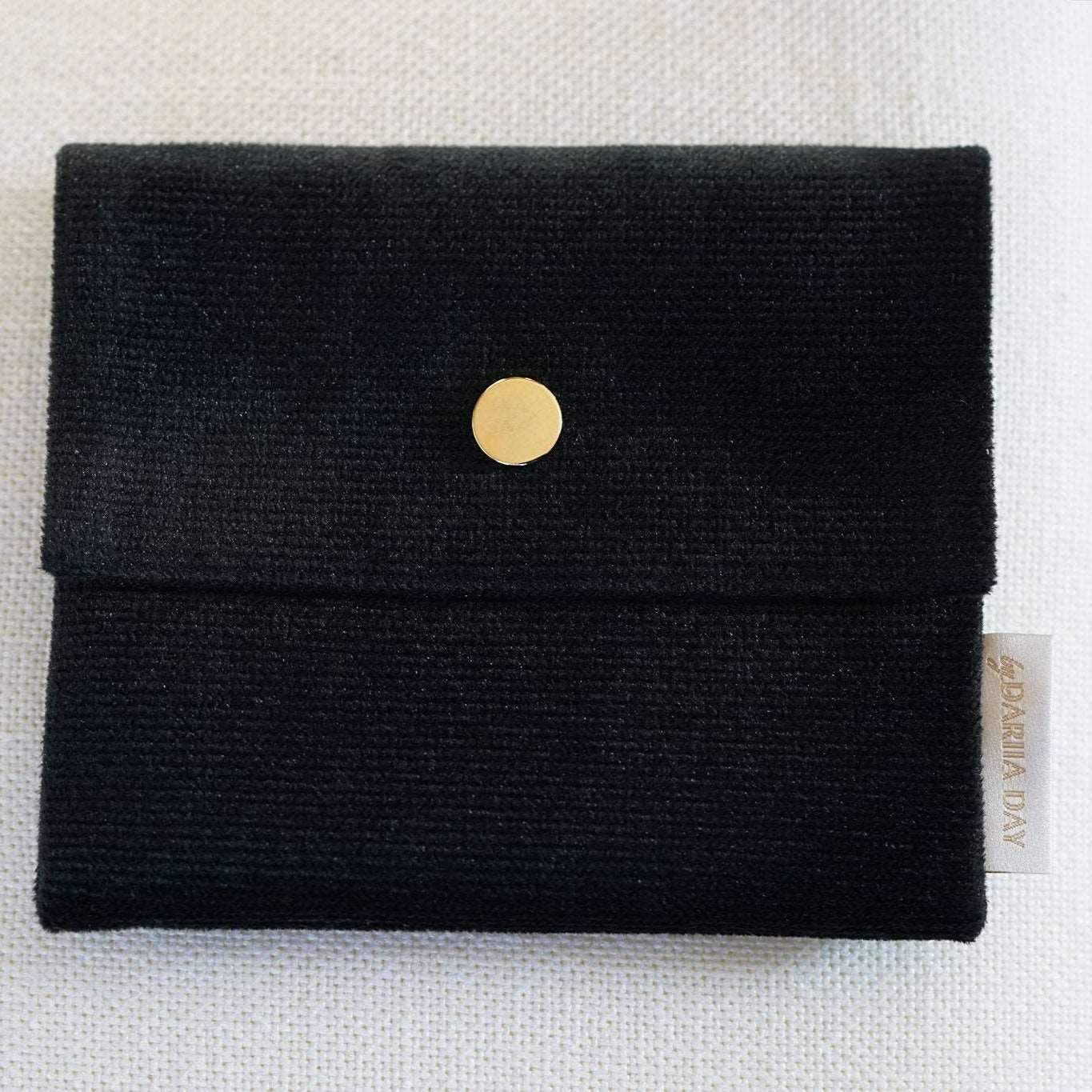 Black Close-up of the small Dariia Day Midnight Black Velvet Pouch on a beige surface.