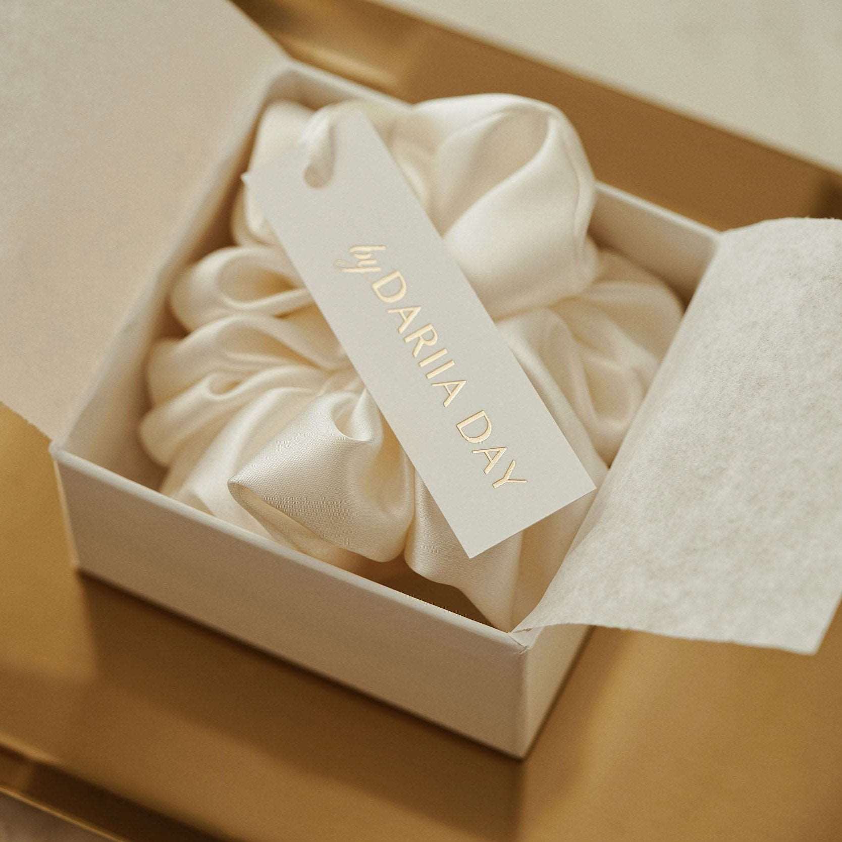 White Powder white silk scrunchie by Dariia Day displayed in a luxurious box on a gold tray, perfect for elegant gift-giving.