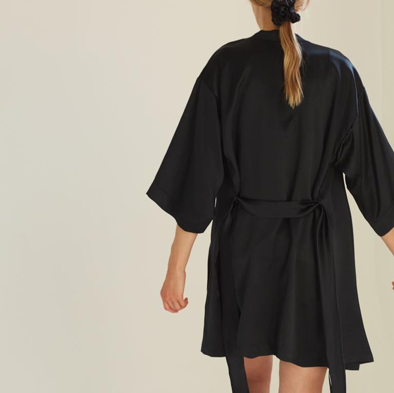 Black silk robe by Dariia Day, back view of model showcasing the smooth drape and luxurious feel of the silk fabric.