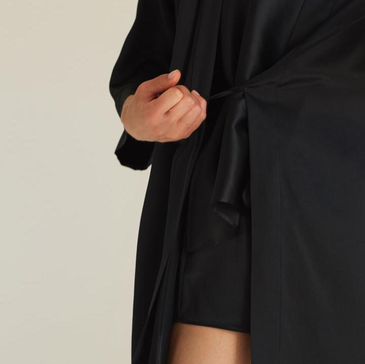 Close-up detail of the tie on the black silk robe by Dariia Day, highlighting the high-quality silk craftsmanship.