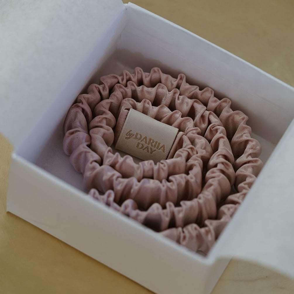 Blush pink silk scrunchie neatly packaged in a gift box by Dariia Day, ideal for hair care and gifting