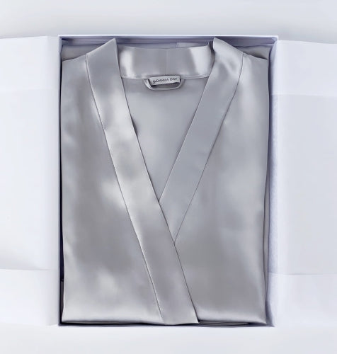 Dariia Day silk robe in silver grey, neatly folded inside the packaging box, highlighting its elegant presentation.