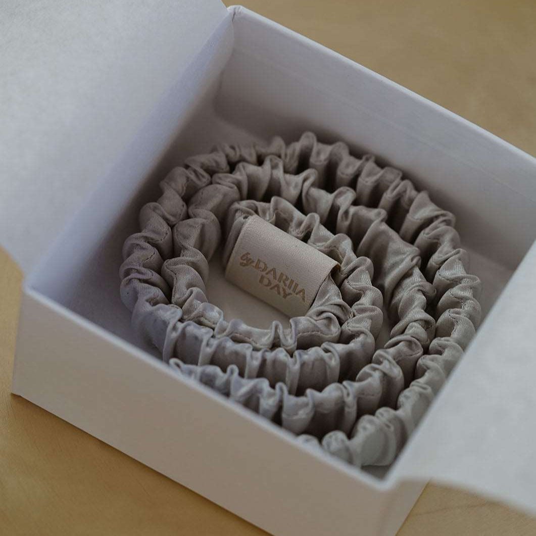 Grey Elegant grey silk scrunchie by Dariia Day, shown in a simple and stylish display, made from premium mulberry silk.