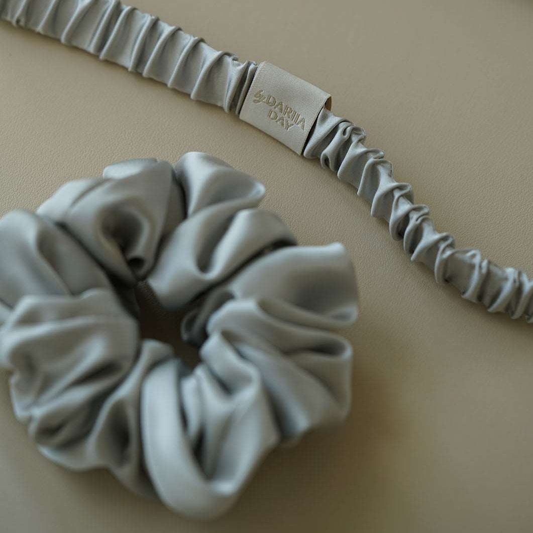 Grey Model wearing a grey silk scrunchie by Dariia Day, highlighting the soft, luxurious texture in naturally curly hair.