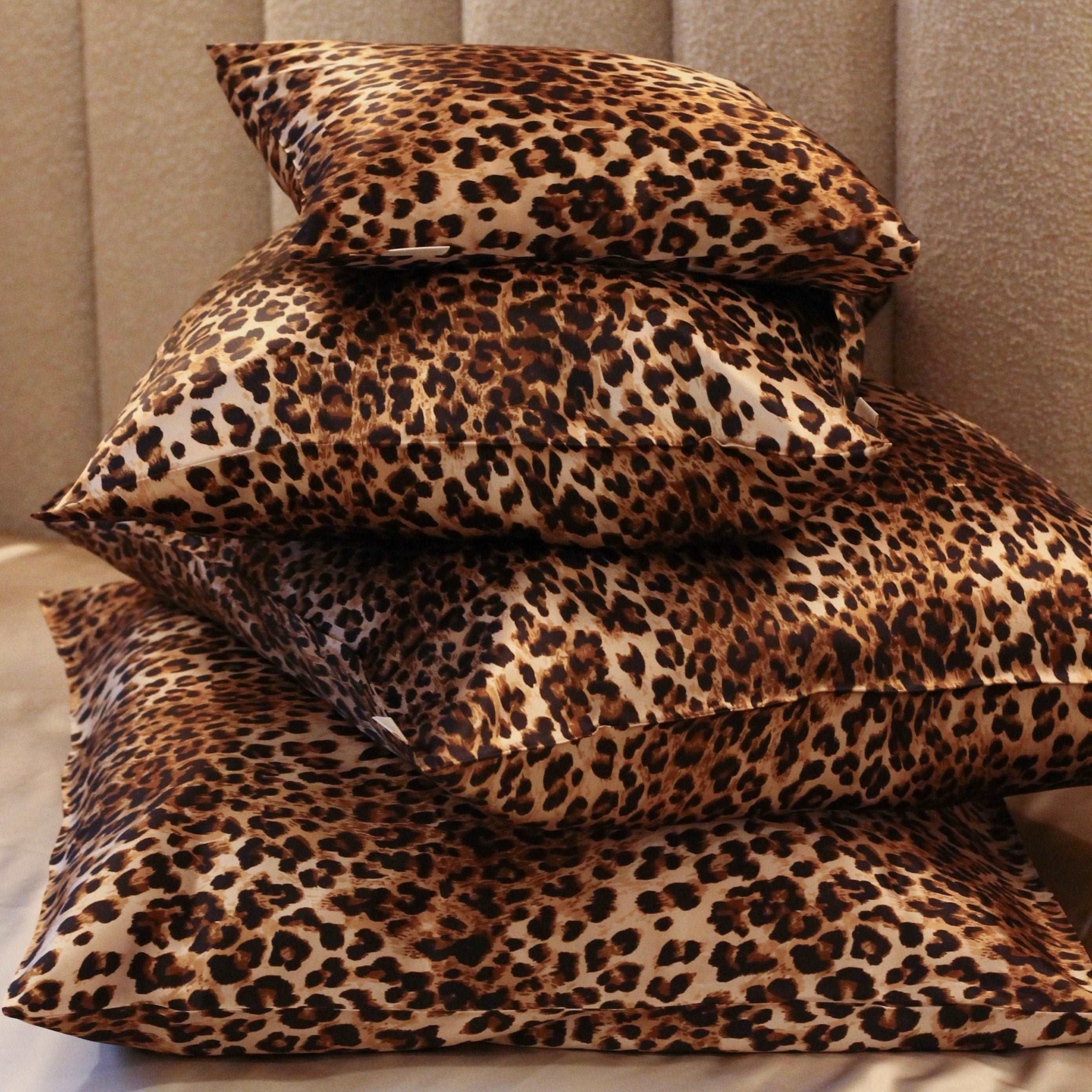 Stack of luxurious leopard print silk pillowcases made from 25 momme mulberry silk, offering a chic and elegant upgrade to your bedroom decor.