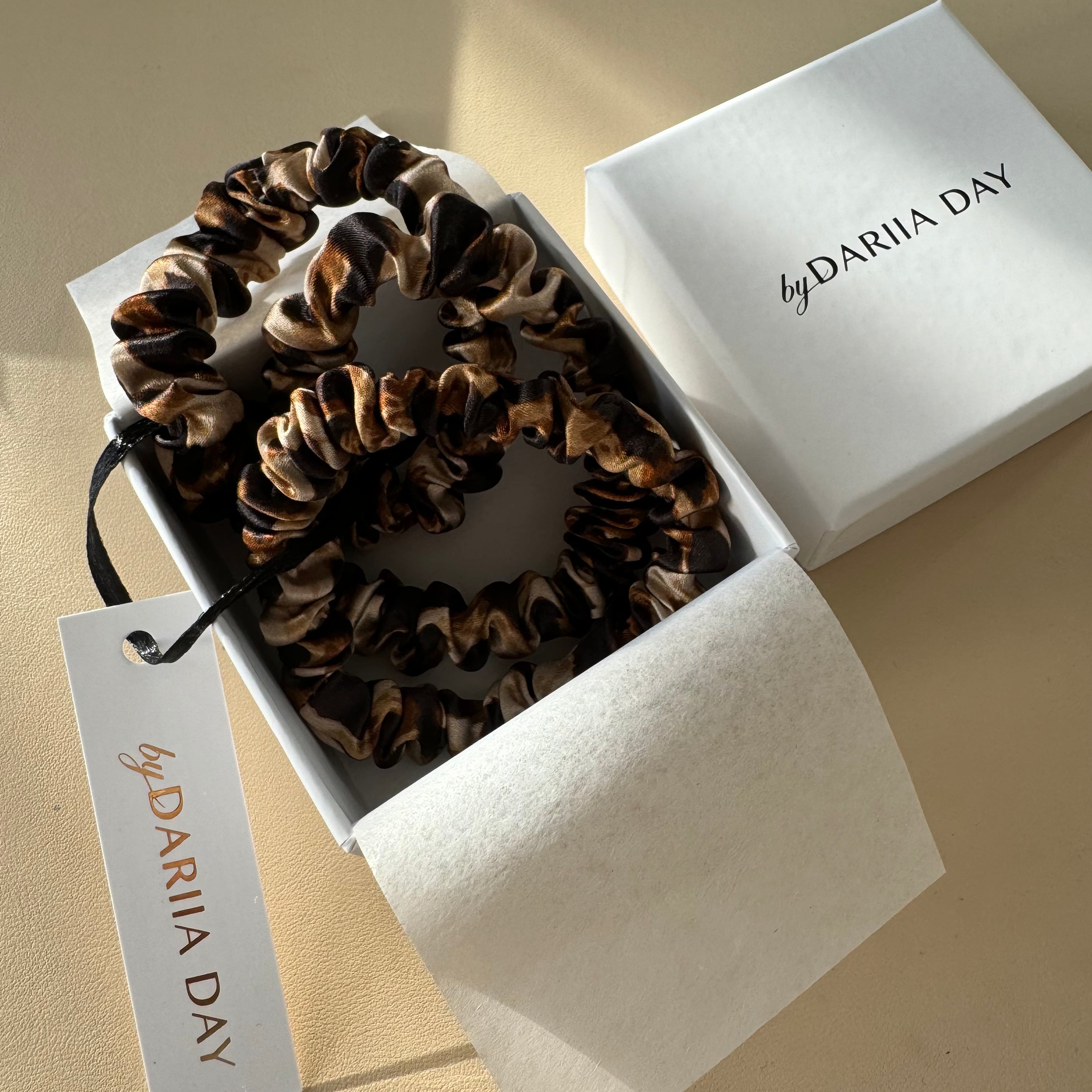 Set of leopard print silk scrunchies presented in an elegant by Dariia Day gift box, crafted from 25 momme mulberry silk for luxurious hair care and style.