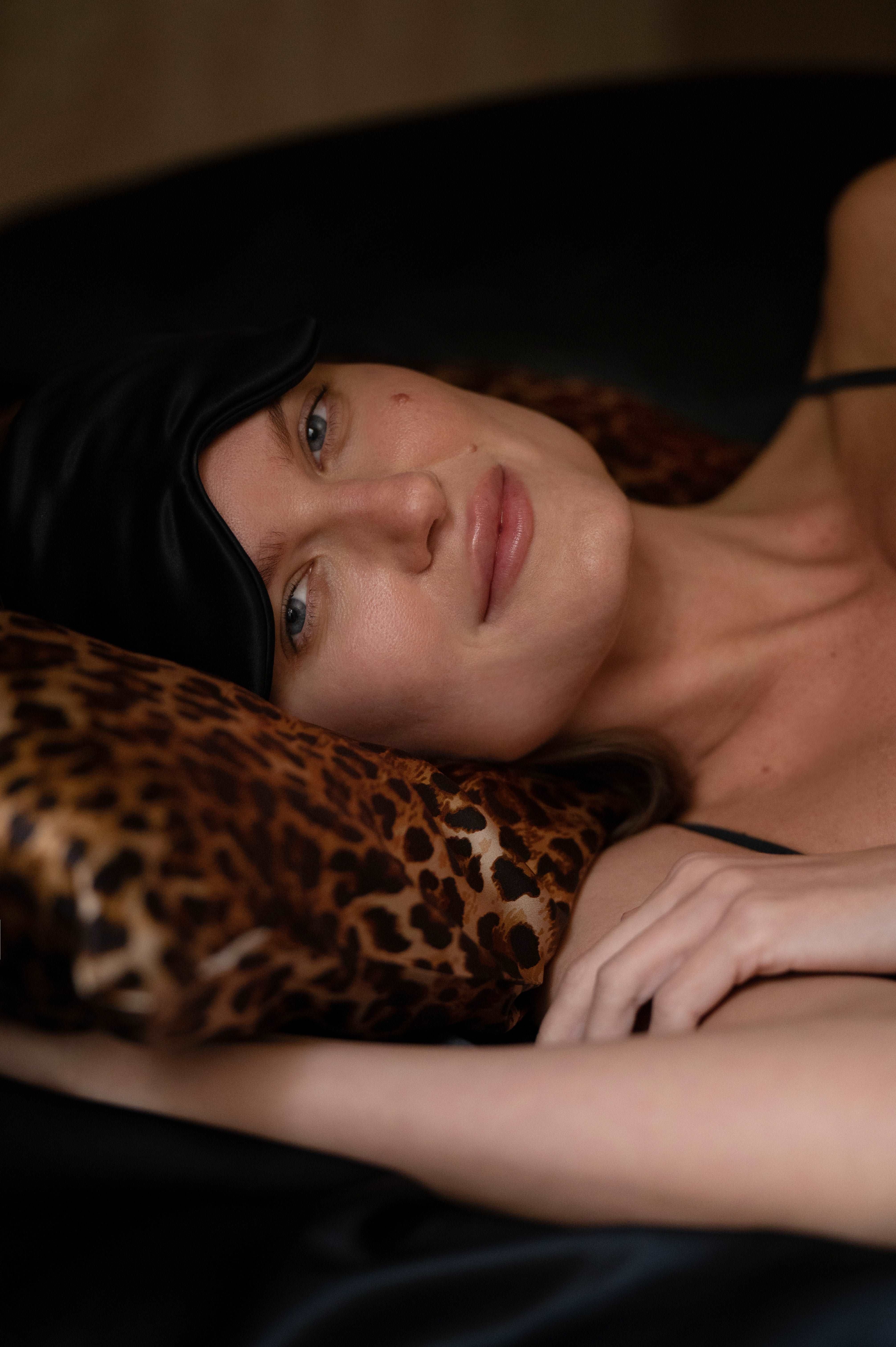 Leopard print silk pillow paired with a black silk eye mask, both crafted from 25 momme mulberry silk, offering a luxurious and restful sleep experience.