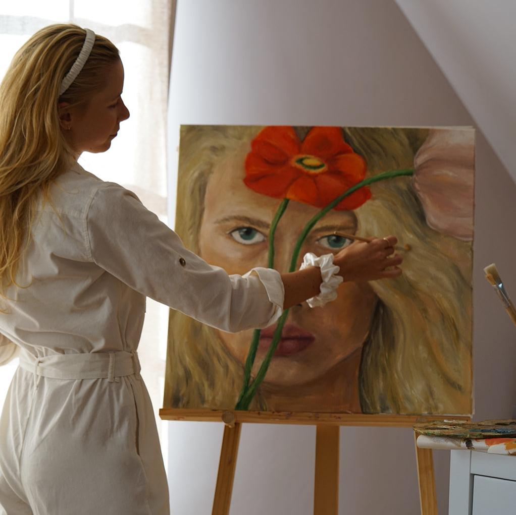 Female artist wearing by Dariia Day Powder White Silk Headband and Scrunchie while painting, showcasing luxurious hair protection with mulberry silk.