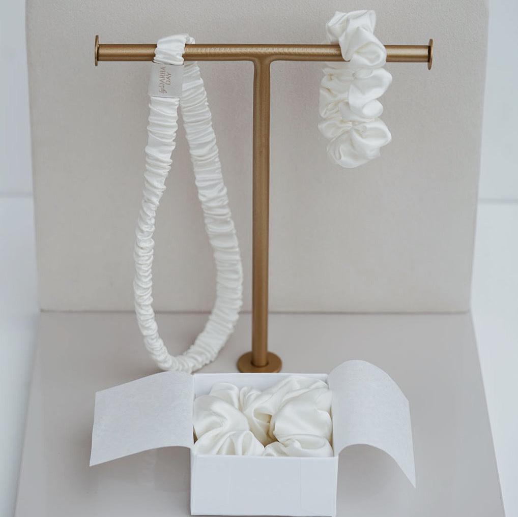 Elegant display of by Dariia Day Powder White Silk Headband and Scrunchie Set, designed for gentle hair care with smooth mulberry silk.