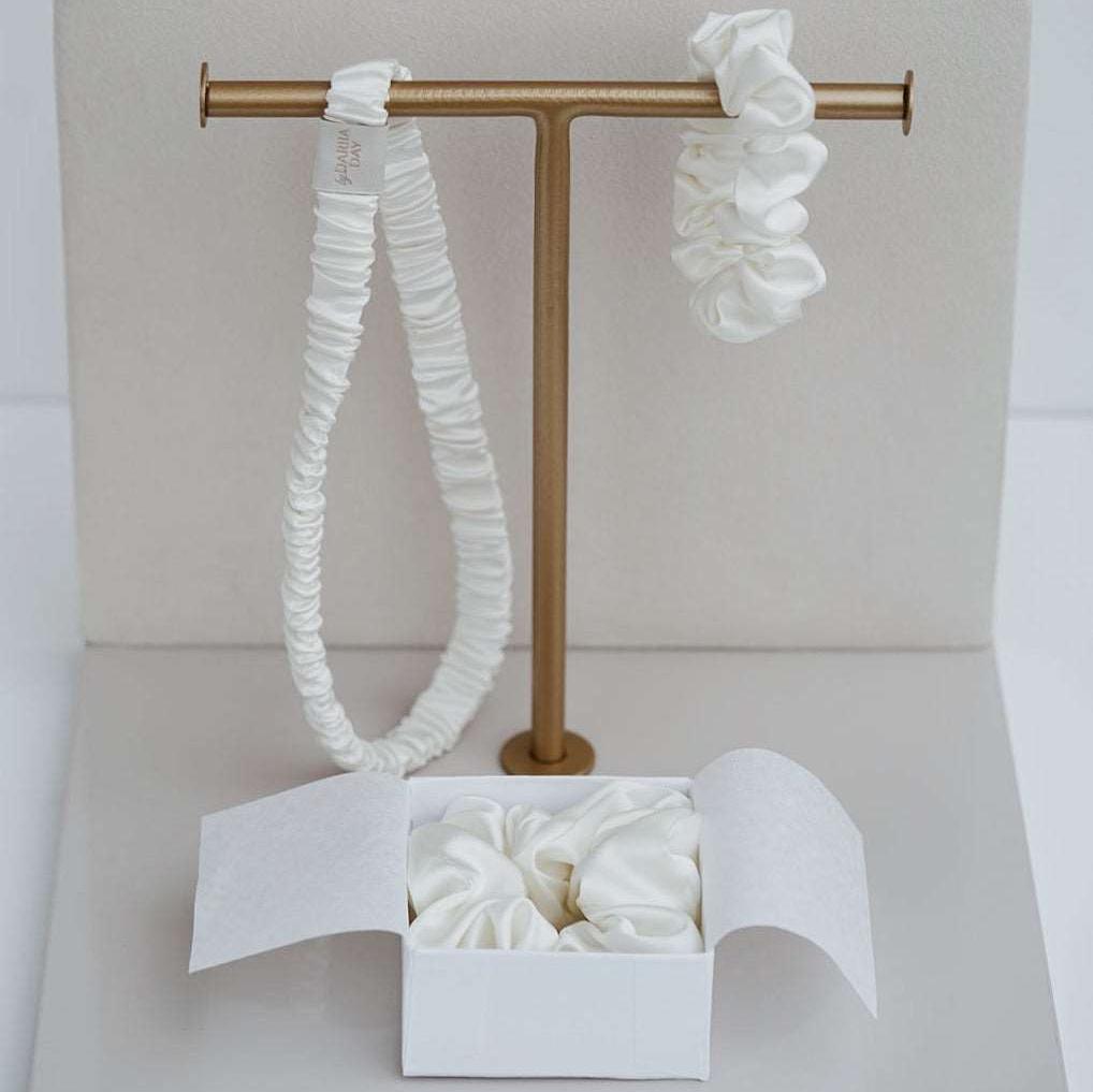 Elegant display of by Dariia Day Powder White Silk Headband and Scrunchie Set, designed for gentle hair care with smooth mulberry silk.