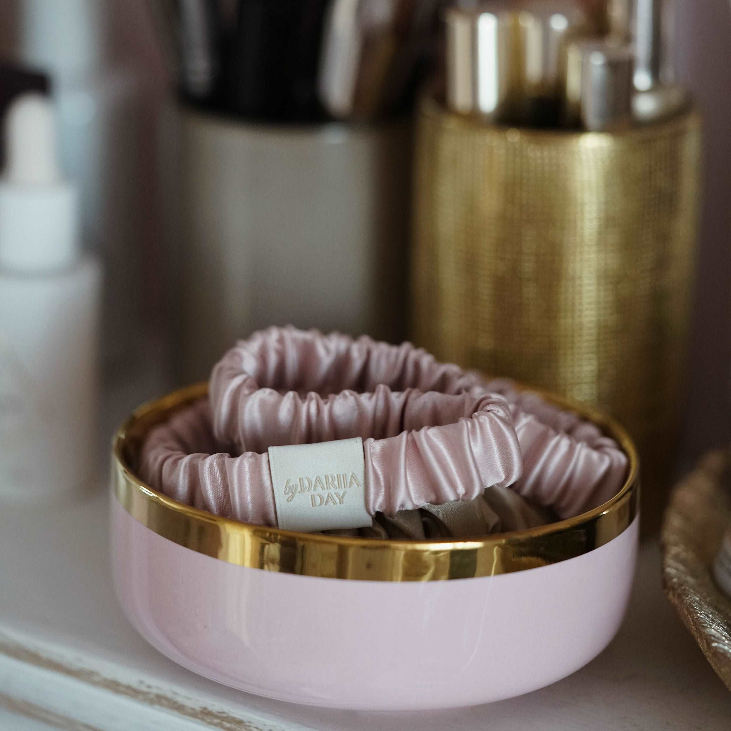 Blush pink silk headband by Dariia Day, displayed in an elegant decorative bowl, perfect for stylish hair care