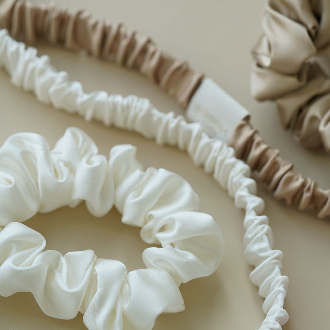 Close-up shot of by Dariia Day Silk Scrunchie and Headband Set in Powder White, offering gentle hold and elegance with natural silk.