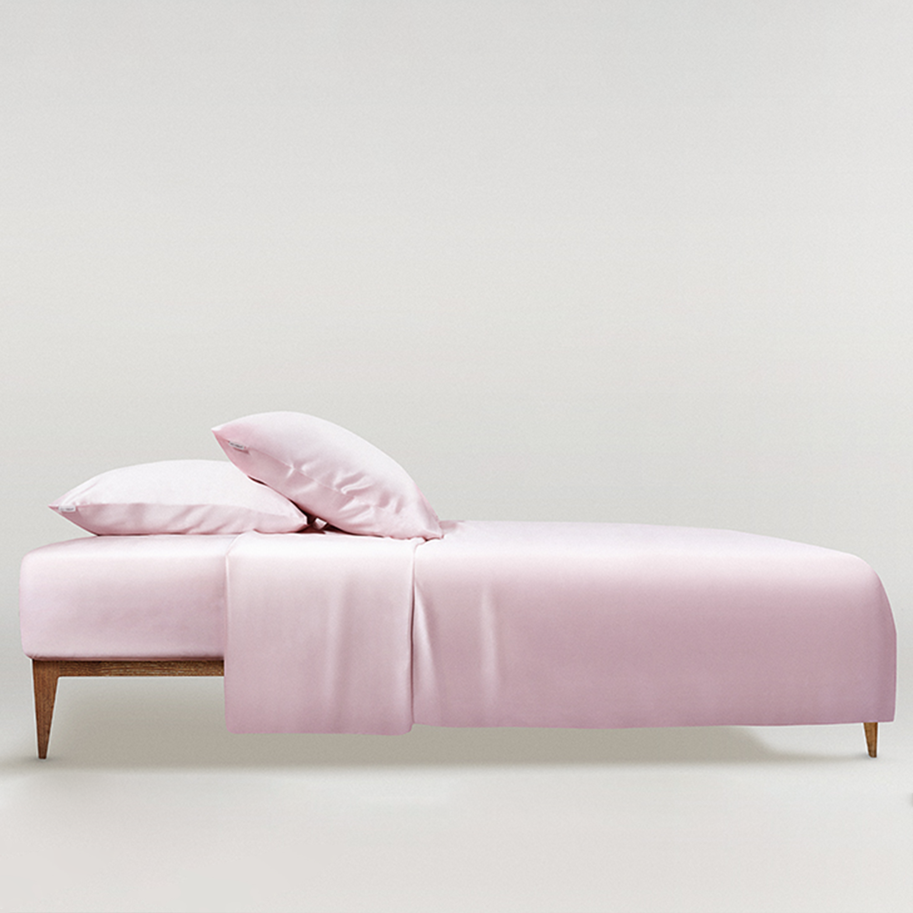 Pink Minimalist bedroom featuring a powder white silk duvet cover and pillows by Dariia Day, highlighting the soft and smooth texture of the luxurious silk bedding.