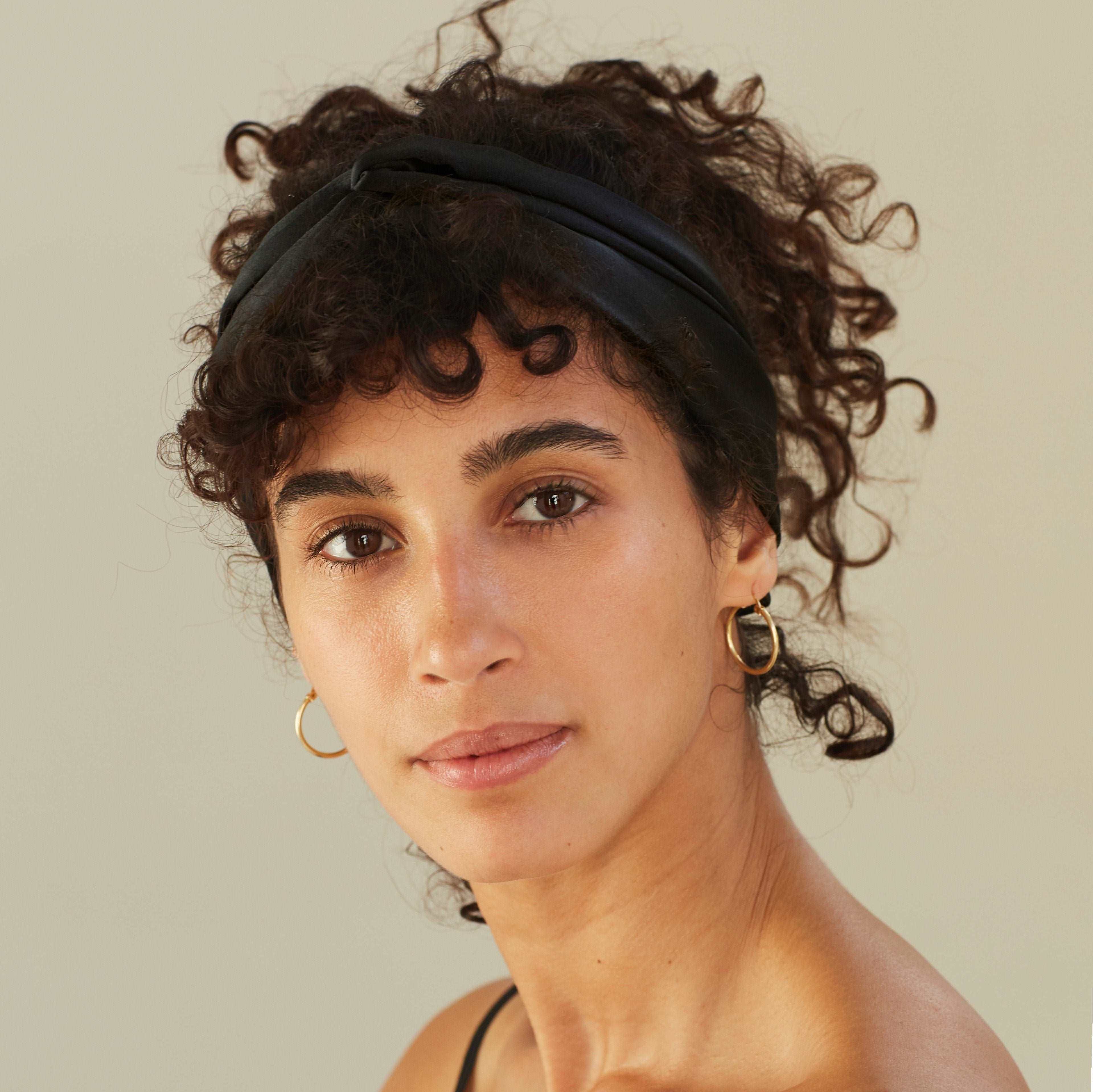 Woman wearing a silk scarf in midnight black as a headband, by Dariia Day