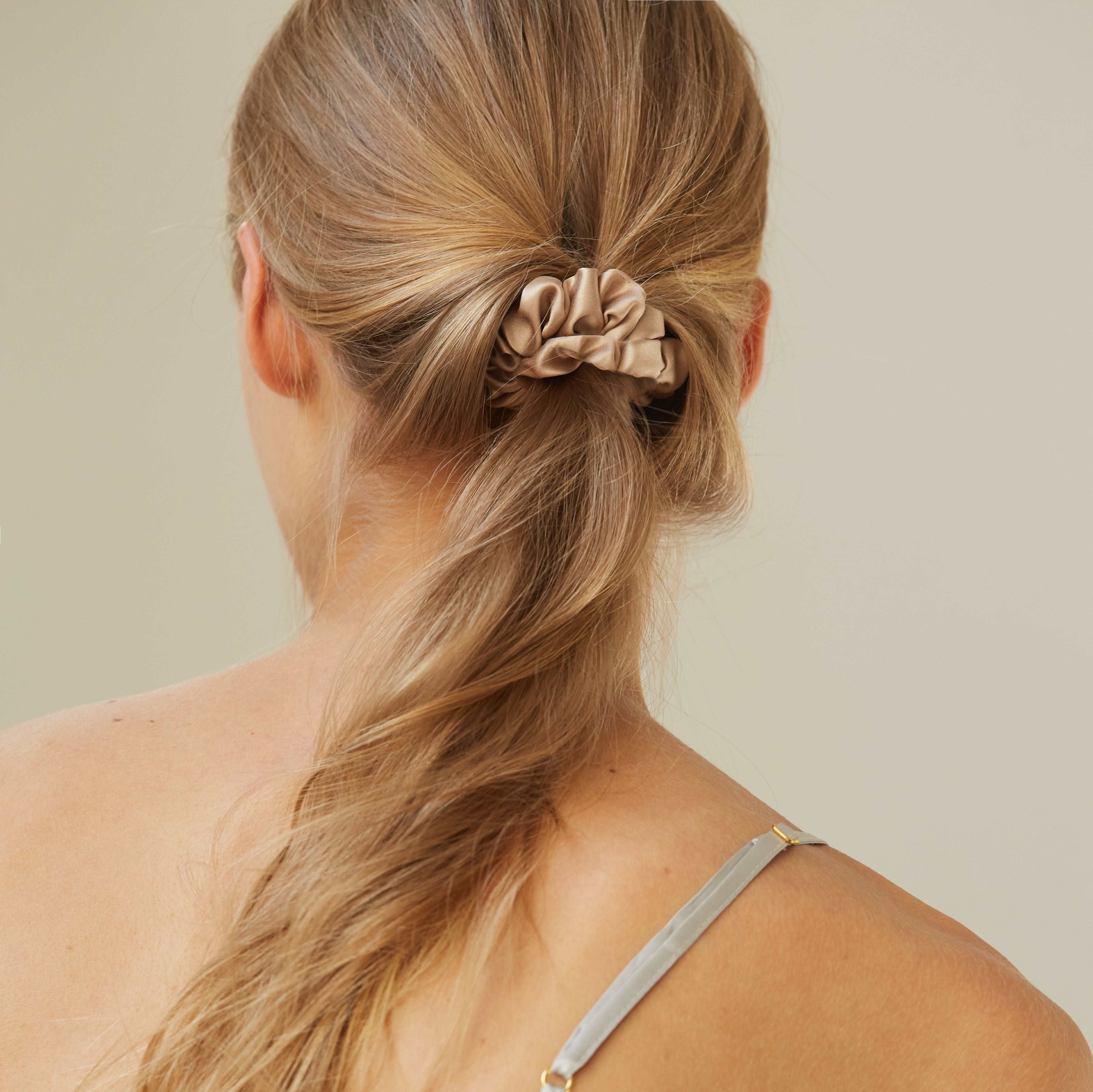 Beige silk scrunchie by Dariia Day styled in straight hair, showing off its luxurious fabric