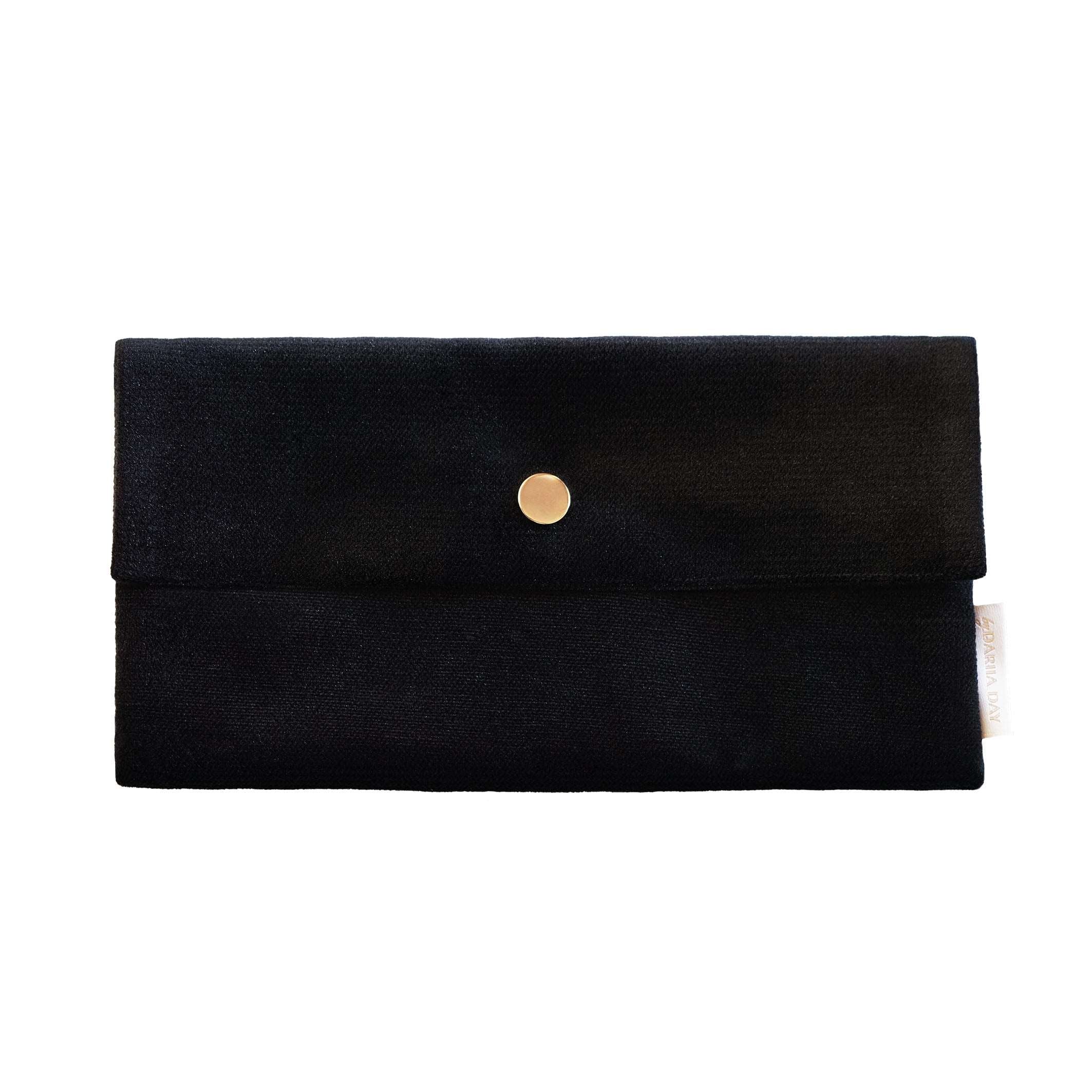 Black Minimalistic black pouch with gold button closure designed for carrying a French beige silk face mask.