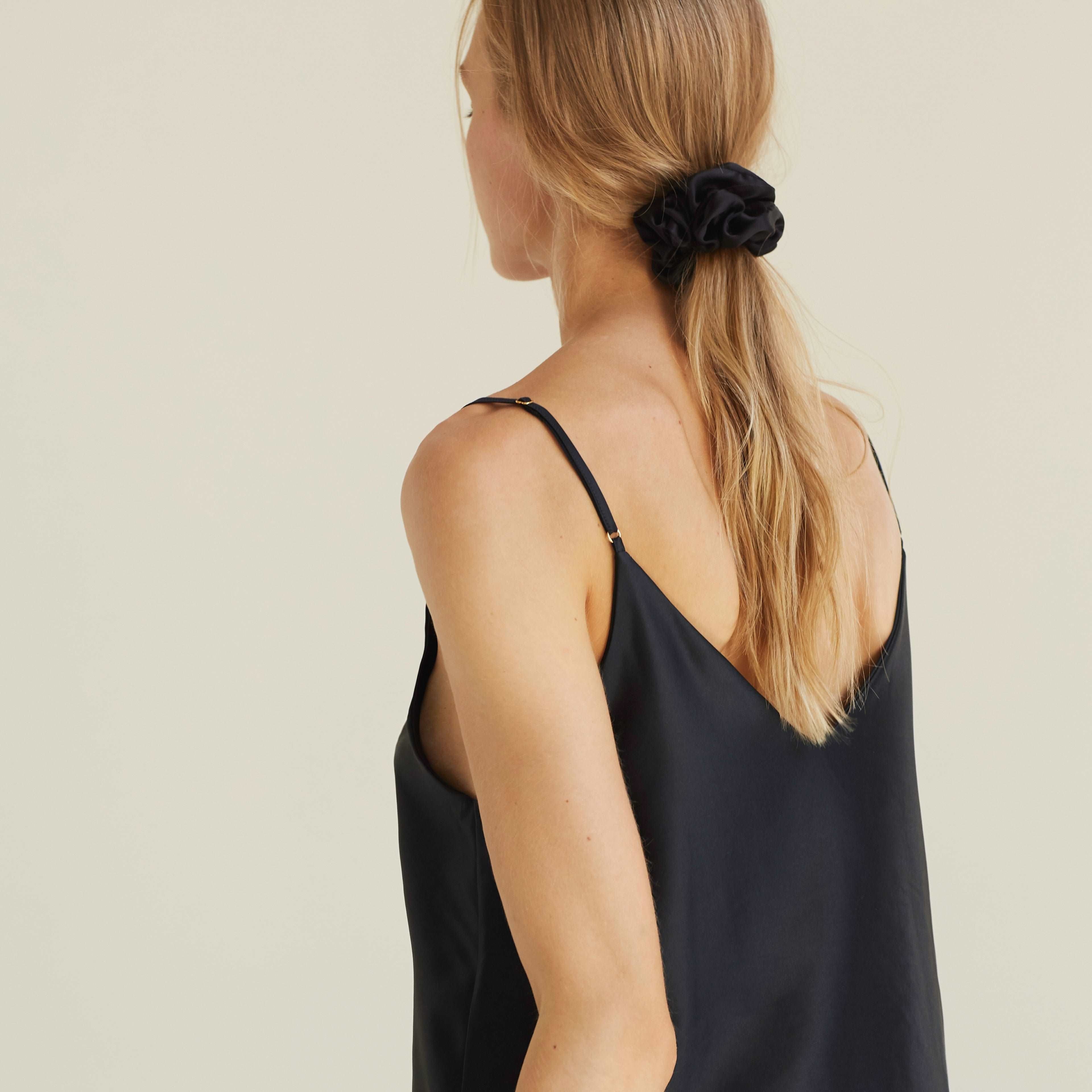 Black silk scrunchie styled in hair, worn with a matching black silk outfit by Dariia Day