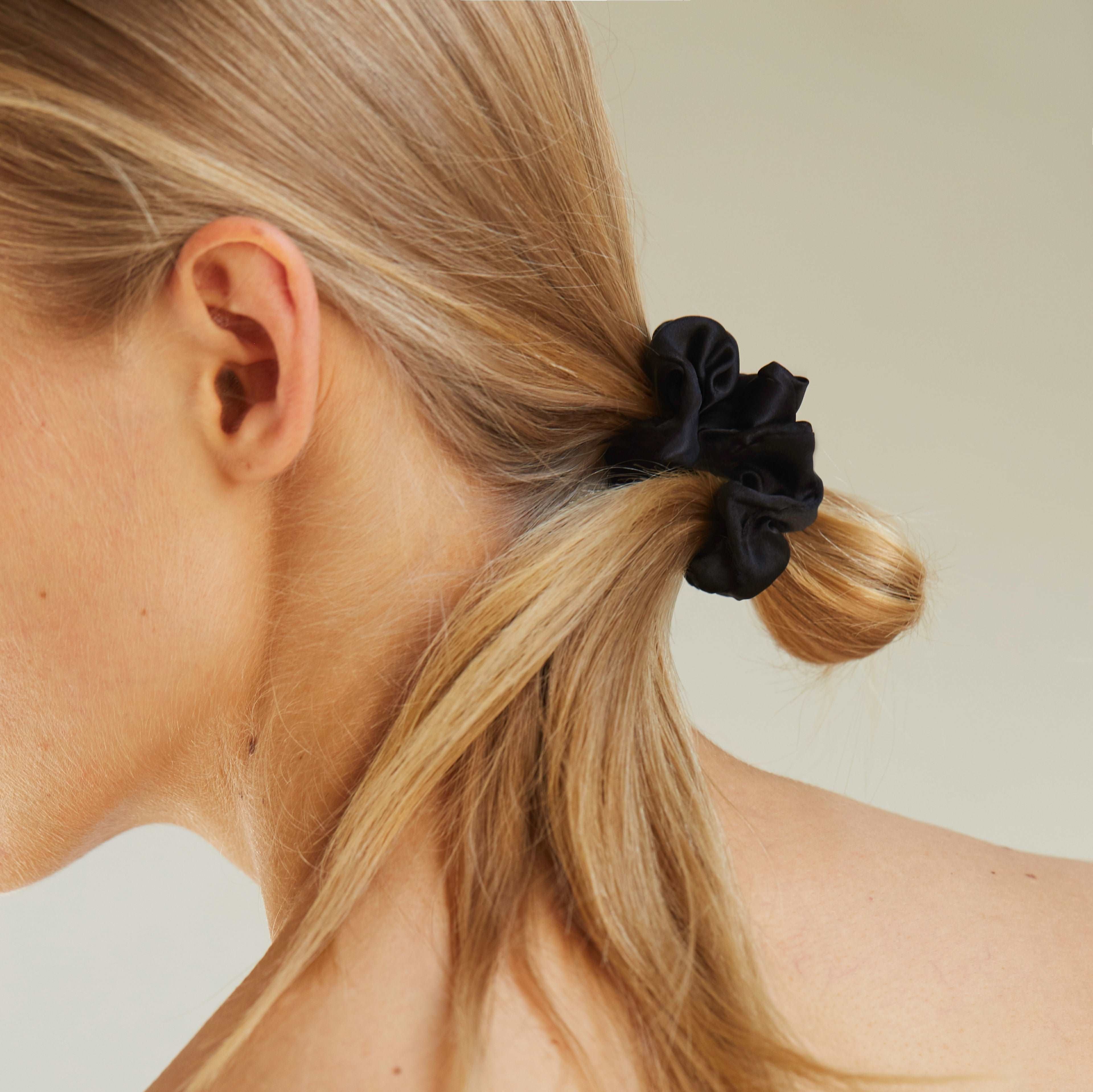 Black silk scrunchie by Dariia Day styled in hair, showcasing luxurious texture