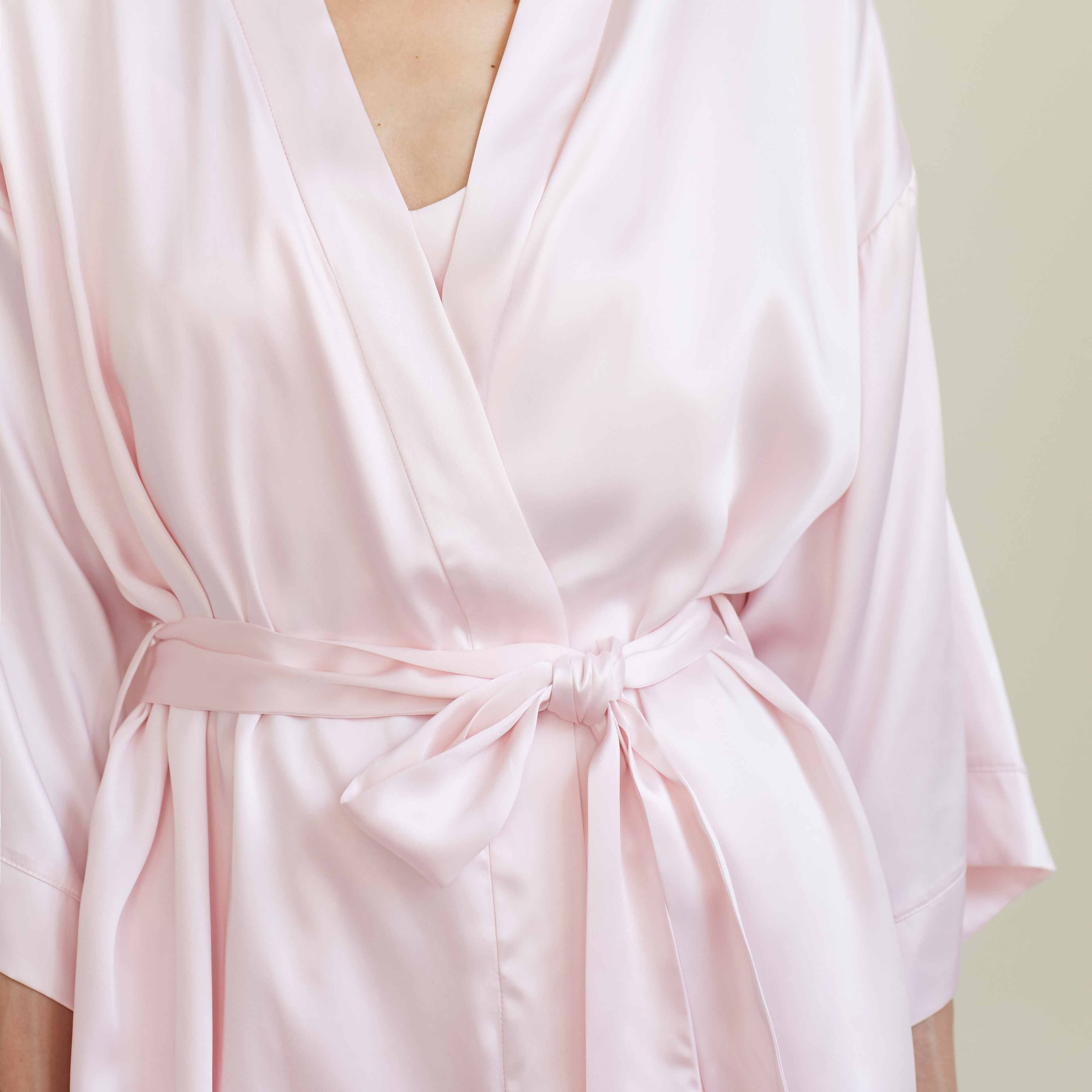 A close-up view of the blush pink silk robe by Dariia Day, focusing on the tie front detail that adds elegance and sophistication to the luxurious robe.