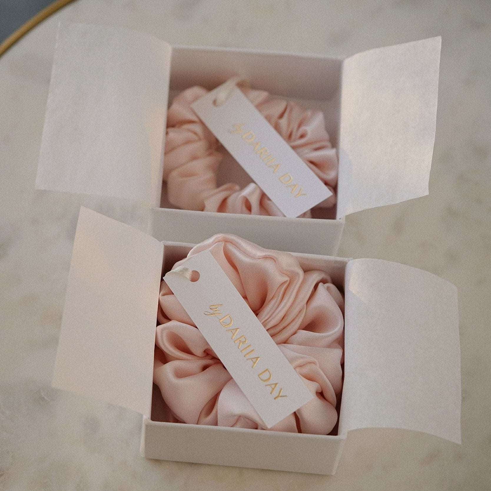 Blush pink silk scrunchies by Dariia Day in elegant white gift boxes, perfect for gifting