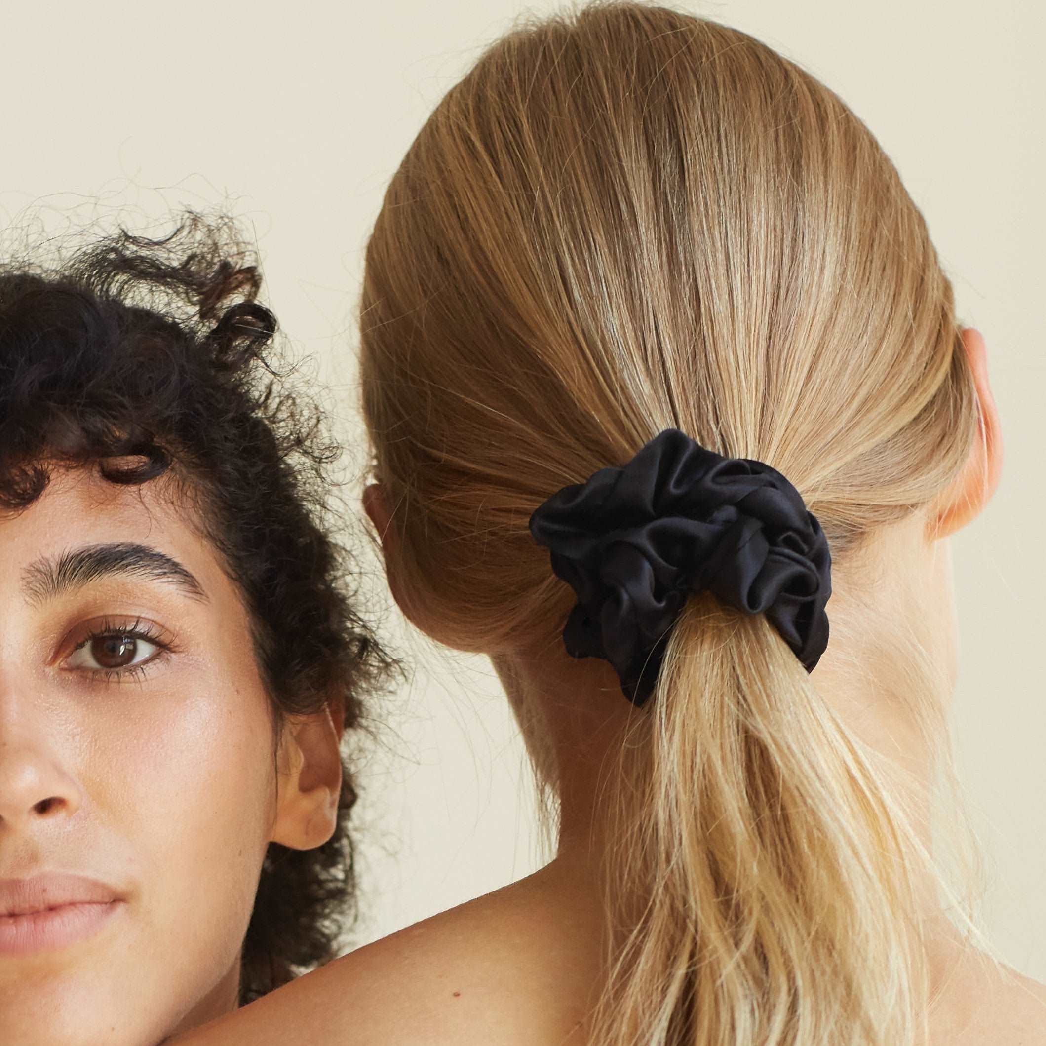 Midnight Black silk scrunchie by Dariia Day worn in long blonde hair, highlighting its smooth texture and elegant look.