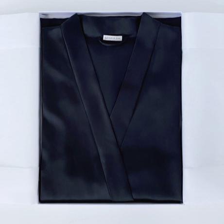 Close-up of a black silk robe by Dariia Day, folded in a gift box, highlighting the smooth fabric and brand label.