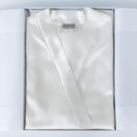 Powder white silk robe by Dariia Day, neatly folded in a gift box with the brand label visible.