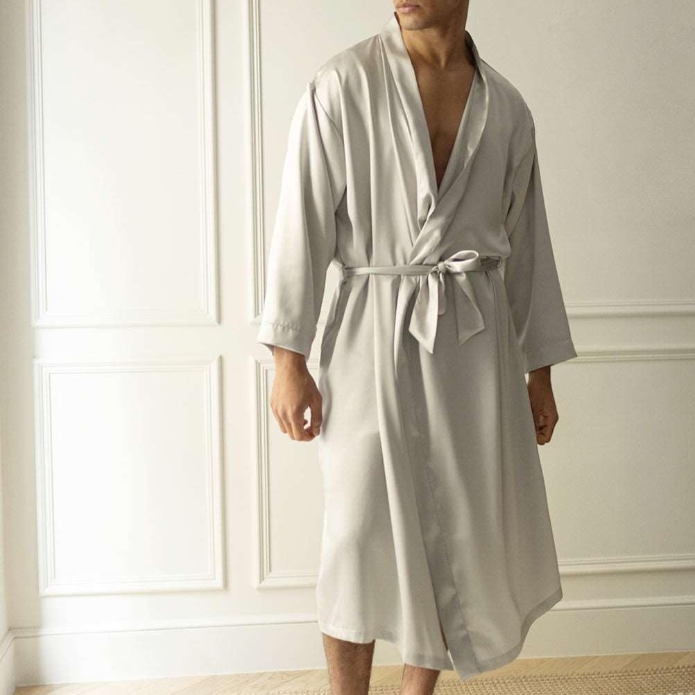 Man wearing a silver grey silk robe by Dariia Day, standing in a softly lit room with natural light.