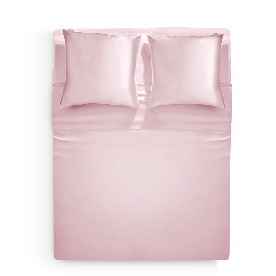 Top view of a pink blush silk duvet cover set by Dariia Day, featuring matching pillowcases, showcasing the luxurious sheen and softness of the fabric.

