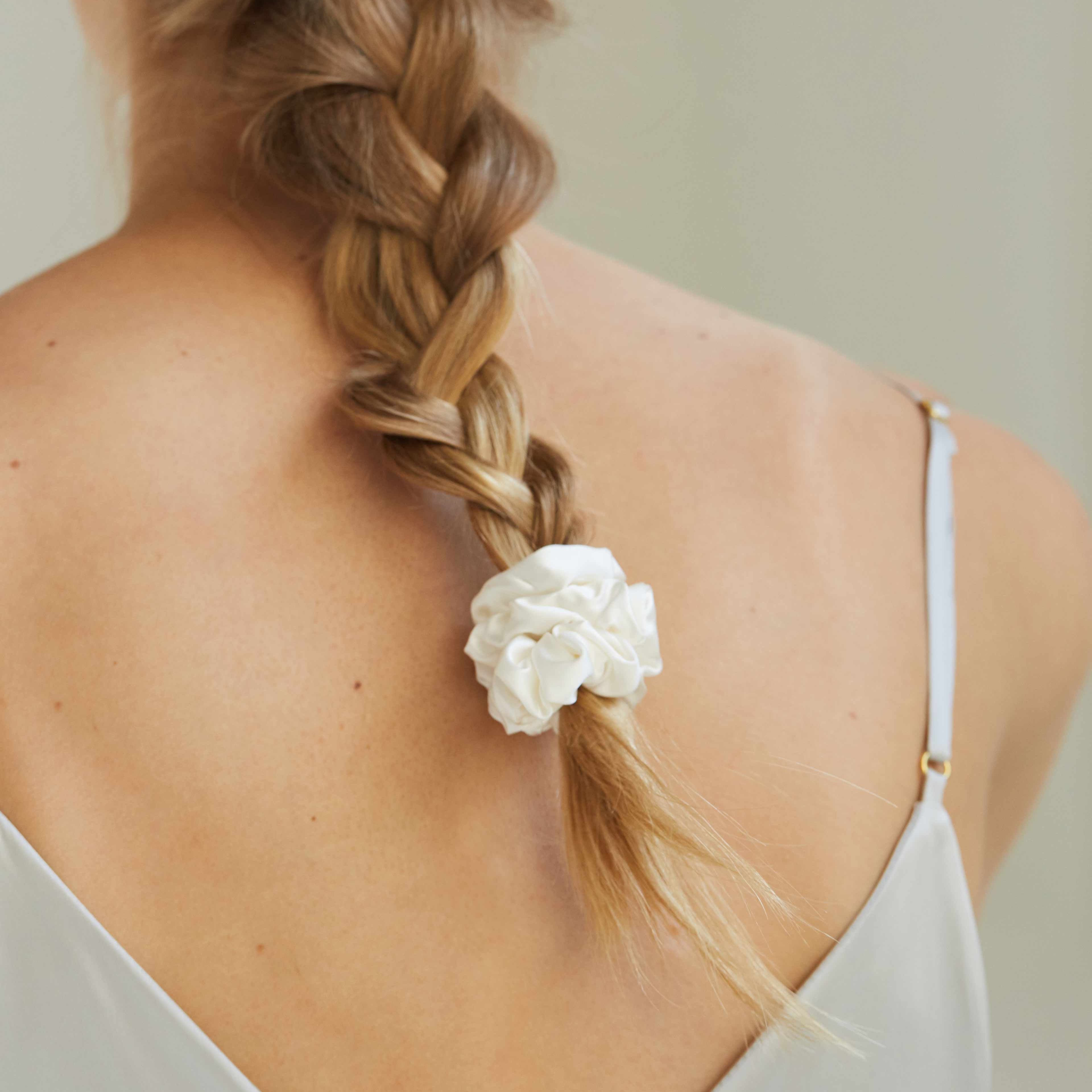 Powder white silk scrunchie by Dariia Day used in braided hair, ideal for protecting hair from damage and breakage.