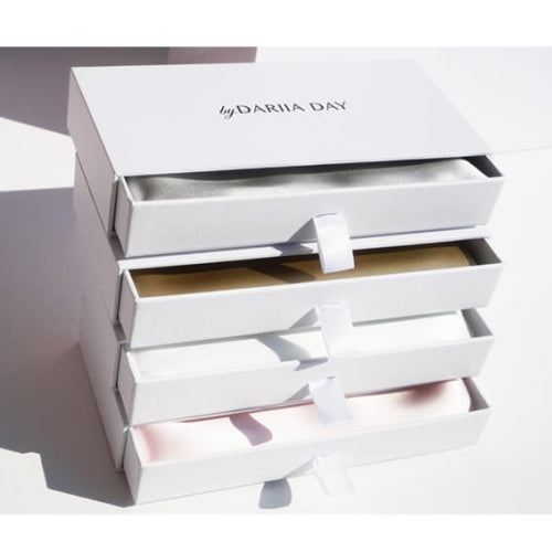 Silk pillowcases set in elegant white boxes by Dariia Day, featuring multiple color options for luxurious bedding.