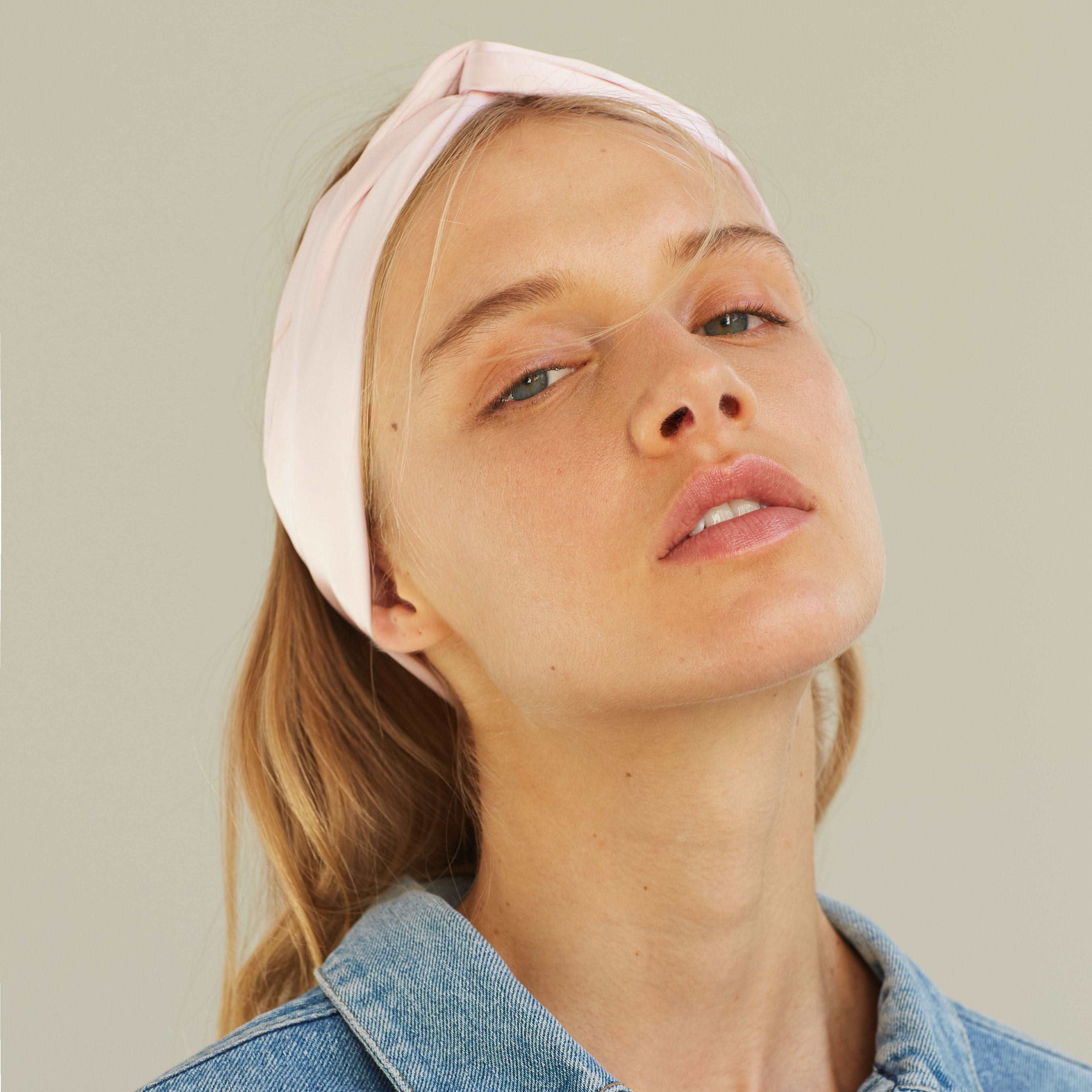 Blush pink silk scarf worn as a headband, paired with a denim jacket, by Dariia Day.