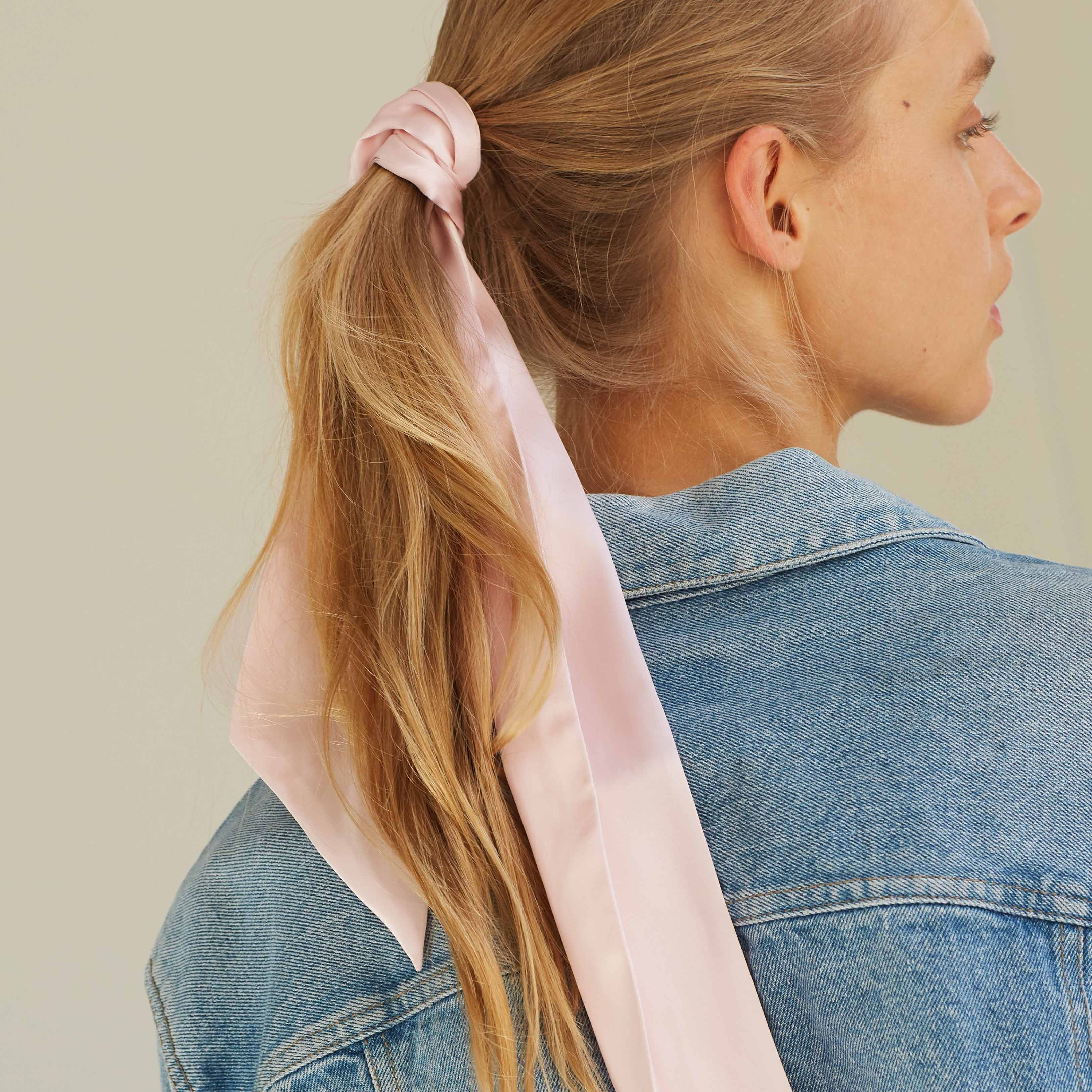 Pink Blush pink silk scarf tied around a ponytail, styled casually with a denim jacket, by Dariia Day.