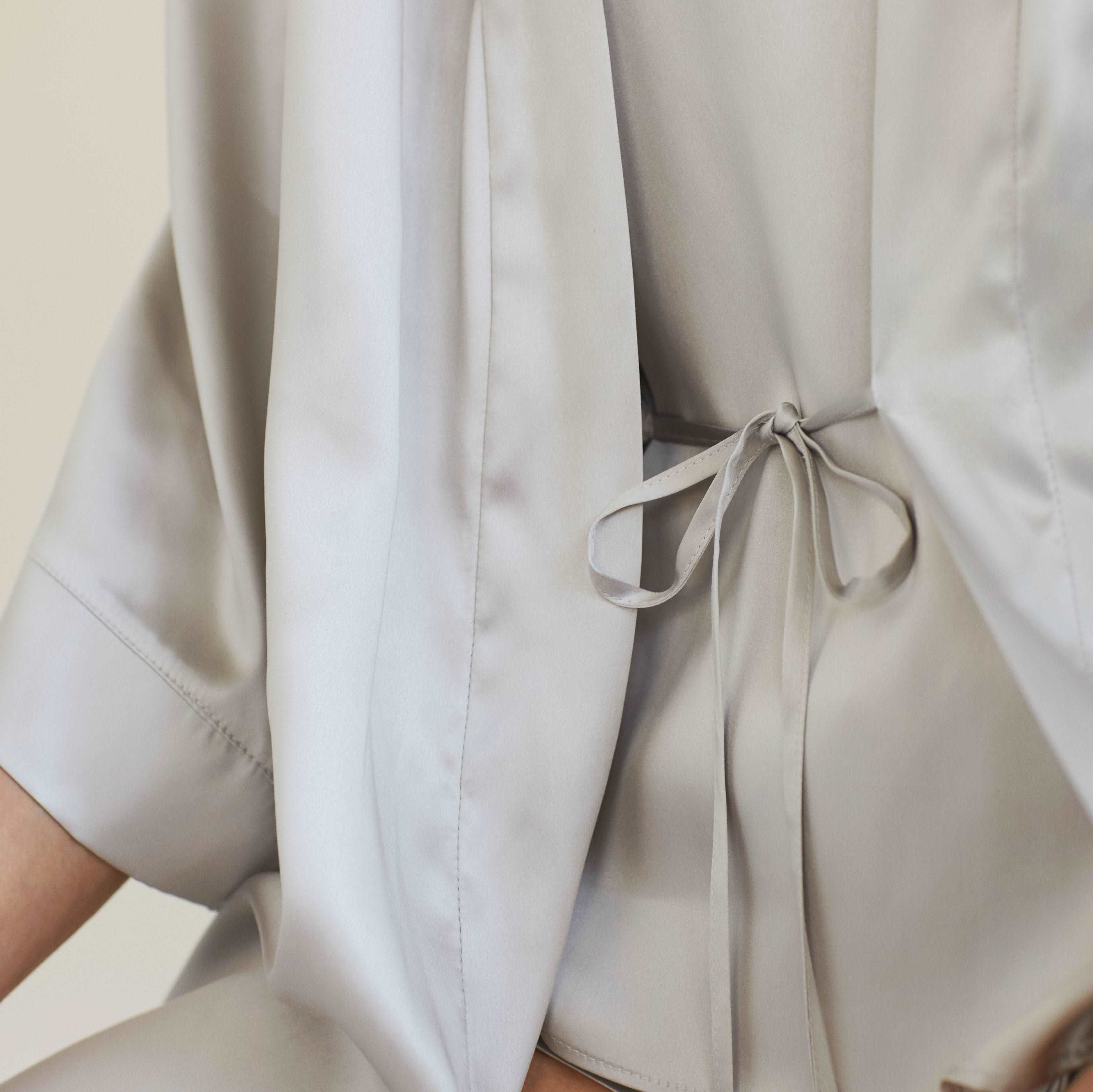 Close-up of the back tie detail of the silver grey silk robe by Dariia Day, highlighting its sleek and refined design.